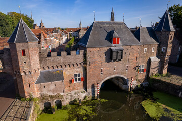 Aerial closeup view double gated medieval city entrance Koppelpoort structure in Amersfoort, The Netherlands, with the authentic rooftops of the historic center in the background