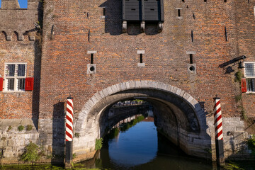 Passage gate Koppelpoort for water traffic and transport at entrance city wall of Amersfoort with arch reflecting in the still water