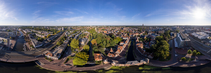 180 degree panorama with reflection of the double gated medieval city entrance Koppelpoort structure in Amersfoort, The Netherlands, reflecting in the Rijn canal water in the foreground on a sunny day
