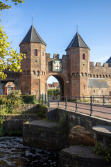 Double gated two tower entry bridge to medieval city through two tower gateway with weapon of the town in the brick overhang