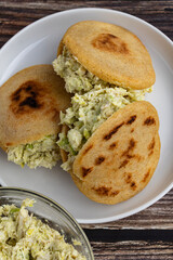 Venezuelan arepa Reina Pepiada stuffed with shredded chicken and creamy avocado. Authentic Latin street food with traditional homemade flavor