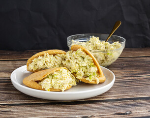 Venezuelan arepa Reina Pepiada stuffed with shredded chicken and creamy avocado. Authentic Latin street food with traditional homemade flavor