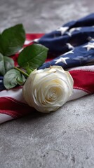 American flag placed next to a white rose and candle, symbolizing peace and remembrance.