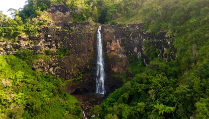 Lush waterfall cascading down rocky mountainside