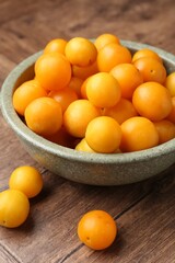 Ripe yellow cherry plums on wooden table, closeup