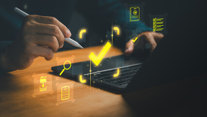Hand using pen on laptop with glowing check mark icon, symbolizing digital approval, online...