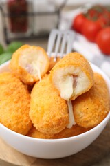 Delicious fried croquettes in bowl on table, closeup