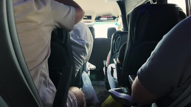 Passengers traveling inside a minibus on a sunny day