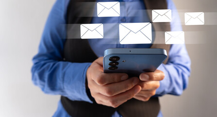 Businesswoman holding her cell phone with various email icons floating around
