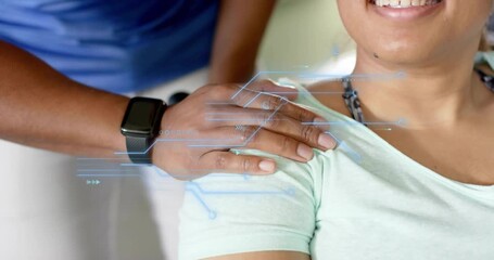 Standing man activating smartwatch projecting tech circuits as pressing her shoulder for comfort - Powered by Adobe