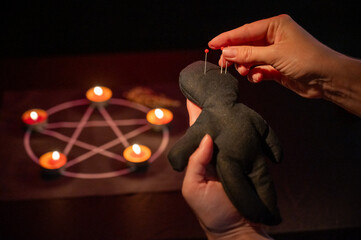 Woman sticking pins into voodoo doll. 