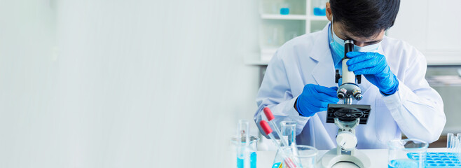 Banner Scientist man look Microscope research in science laboratory. Banner Asian scientist use microbiology microscope in laboratory equipment chemistry lab. Biochemistry experiment with copy space