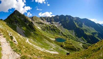 Obraz premium Mountain panorama with a winding path and alpine lake