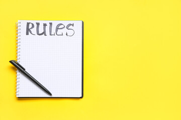 Blank notebook with word RULES on yellow background