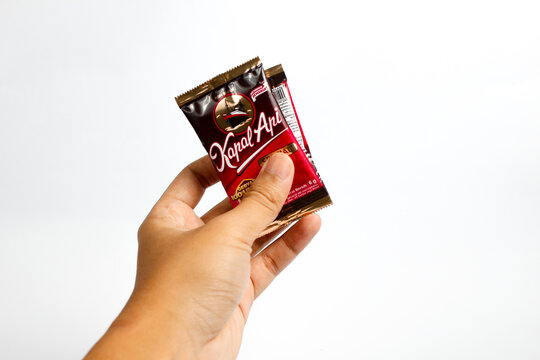 Indonesia, Sukoharjo - June 19, 2025 : holding a sachet of ground coffee product steamer (Kapal Api )brand from Indonesia, Isolated on white background