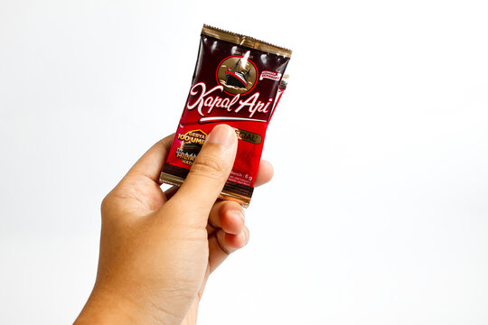 Indonesia, Sukoharjo - June 19, 2025 : holding a sachet of ground coffee product steamer (Kapal Api )brand from Indonesia, Isolated on white background