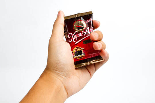 Indonesia, Sukoharjo - June 19, 2025 : holding a sachet of ground coffee product steamer (Kapal Api )brand from Indonesia, Isolated on white background