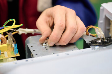 Assembly process of microwave oven electrical components on conveyor system in manufacturing facility