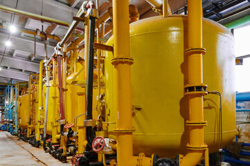 Storage tanks in industrial facility during daylight hours showcasing extensive piping and machinery