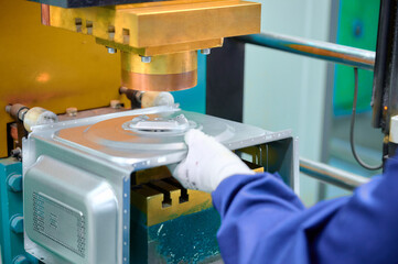 Spot welding process taking place on microwave oven casing in a manufacturing facility