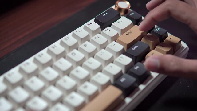 Close-up finger pressing Enter key on a modern mechanical keyboard with unique keycap design.