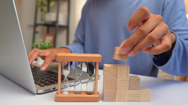 Building wooden blocks beside a laptop, this person embodies continuous self-development, reflecting growth mindset, creativity, lifelong learning, resilience, and the drive for personal progress.
