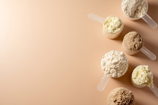 Protein powder in scoops. Different flavours of whey protein powder, copy space.