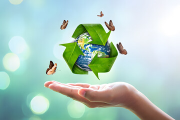 Embracing Sustainability A Hand Offering a Globe Encased in a Recycle Symbol Surrounded by Butterflies Representing Environmental Consciousness and Renewal