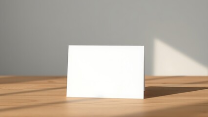 A simple blank card on a wooden surface, embodying minimalist elegance with soft lighting.