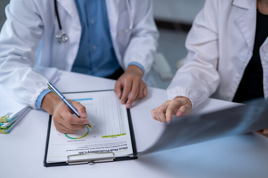 Doctors analyzing medical chart and x-ray for diagnosis
