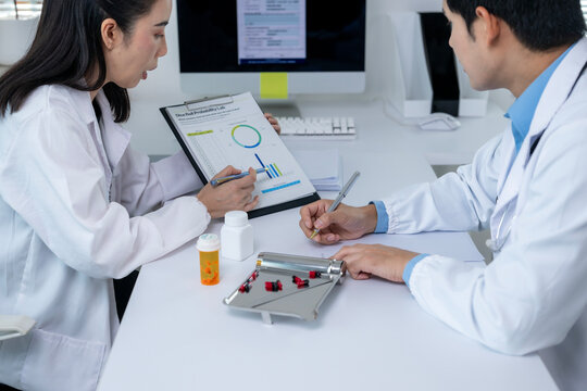 Doctors analyzing medical chart with medication and pill counting tray - Powered by Adobe