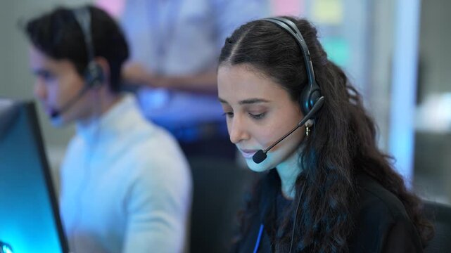A technical man and woman support specialist handles an escalated ticket in all day contact center. She navigates the CRM and knowledge base to achieve First Call Resolution for a client.