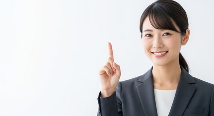 1番目のジェスチャーをしている笑顔の日本人女性社員