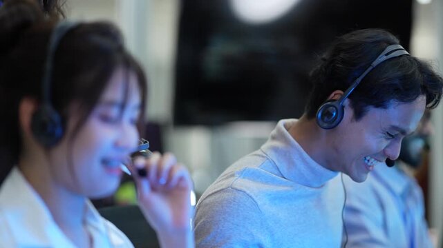 A diverse team of customer support agents works in a modern call center. Smiling operators assist clients over the phone, providing helpful and professional technical support.