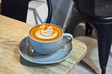Extreme close up view of cafe latte on the wooden table. grey or gray cup, mug. ceramic. art. copy space, empty, free, negative, text, design. brown. white. coffee.