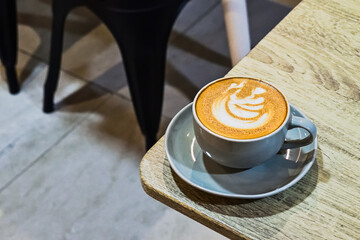 Extreme close up view of cafe latte on the wooden table. grey or gray cup, mug. ceramic. art. copy space, empty, free, negative, text, design. brown. white. coffee.
