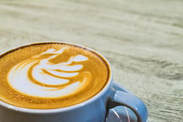 Extreme close up view of cafe latte on the wooden table. grey or gray cup, mug. ceramic. art. copy space, empty, free, negative, text, design. brown. white. coffee.
