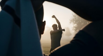 Man stretching arms in open park during early morning sunrise with soft mist, outdoor fitness warmup exercise before running, healthy lifestyle and athletic preparation for active training routine