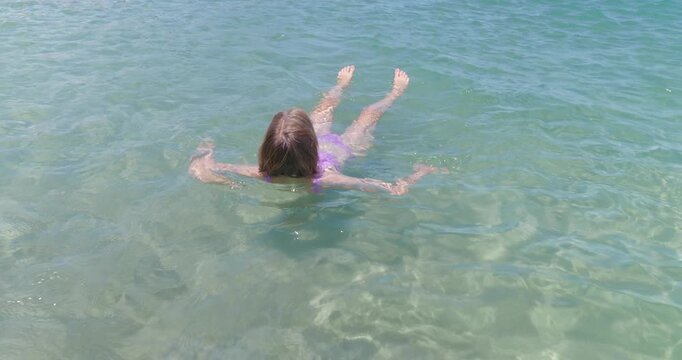 Woman having fun swimming in turquoise warm ocean. Sunny day.