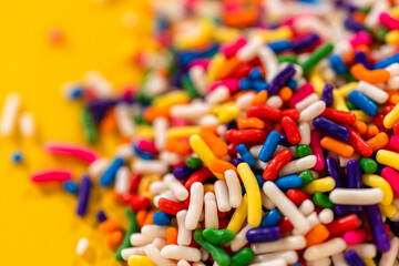 Colorful Candy Sprinkles on Yellow Background