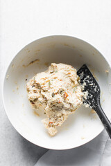 overhead view of savory biscotti dough in a bowl, top view of savory cookie dough in a mixing bowl