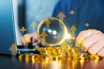 Magnifying glass with gold coins and upward arrows, financial growth, profit, wealth and investment concept