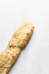 overhead view of bakery savory biscotti log on a parchment lined baking sheet, top view of savory cantucci cookie dough on parchment paper