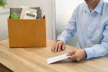 sending resignation letter to boss and Holding Stuff Resign Depress or carrying cardboard box by desk in office