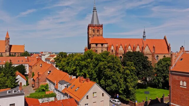 Kości&oacute;ł Wniebowzięcia NMP in Chelmno framed by rooftops in clear sky view
