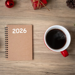 2026 notebook, black coffee cup and Christmas gift on wood table, Top view and copy space. Xmas, Happy New Year, Goals, Resolution, To do list, Strategy and Plan concept