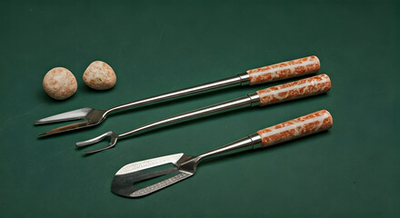 Elegant Stainless Steel Serving Utensils with Decorative Marble Handles and Two Small Speckled Eggs