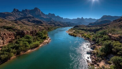 Sunny river winds through arid mountains