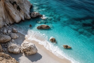 High-angle view of a pristine beach, turquoise water, and rocky shoreline