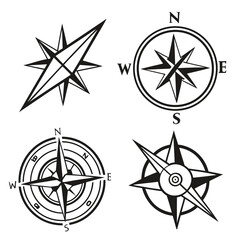 Collection of four black and white compass rose icons and wind rose symbols representing navigation and direction on a clean white background